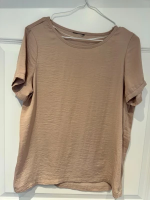 Beige basic t-shirt i bomull - Enkel och stilren beige t-shirt med rund hals och korta ärmar. Tillverkad i mjuk bomull som känns skön mot huden. Perfekt till jeans eller shorts för en clean look.