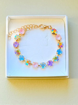 Armband aurora boreale  - Superfint armband med gnistrande stenar  i aurora boreale, ljus rosa, ljus blå, ljus lila. De är  monterade på en guldfärgad kedja. Stenarna är runda och 8mm stora.  Justerbar längd med karbinlås. Perfekt för dig som gillar färg och glitter! Bild 2 är en inspirationsbild hur man kan kombinera med egne smycken från tex Svedbom. Sista bilden är ett urval av färger som finns! 