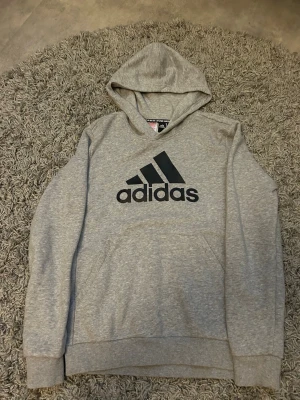 Adidas hoodie - Snygg grå hoodie från Adidas med stor svart logga på bröstet. Jätte bra skick och inget problem med den.
