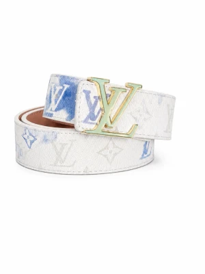 Vitt bälte med blått mönster - Snyggt vitt bälte med ikoniskt monogrammönster i blått och vitt. Bältet har ett stort L och V-spänne i guld och är tillverkat i skinn. Perfekt accessoar för att lyfta vilken outfit som helst.