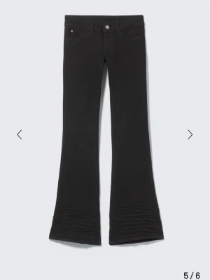 Svarta bootcut jeans från weekday  - Säljer ett par svarta bootcut jeans från Diesel med klassisk femficksdesign och en cool rosa patch på bakfickan. Jeansen har utsvängda ben och är tillverkade i ett stretchigt material som sitter snyggt. Perfekta för dig som gillar en retrostil.