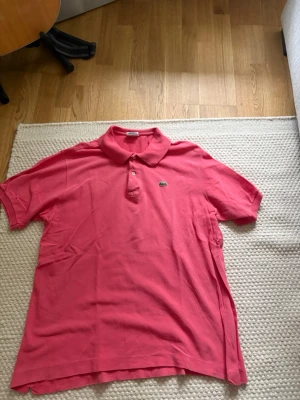 Lacoste pike - Säljer denna piké tröjan från Lacoste. Finns skada på båda sida ärmslut, se tredje bilden Nypris: 1099kr Storlek: 6/XL Mått: Axel-Axel 46cm Armhåla-Armhåla 55cm Längd 68cm