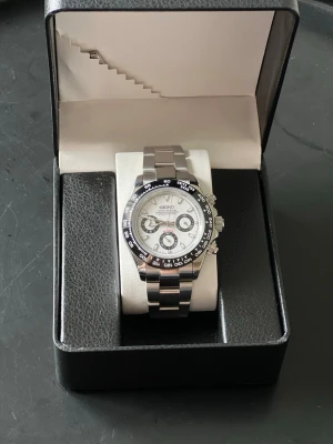 Seiko mod daytona panda - Sprillans ny och väldigt snygg Seiko mod daytona panda. 39mm stor med kronograf och tachymeter. Det är ett äkta Seiko Quartz urverk i den med nytt batteri. Levereras med tre stycken extra länkar. Skriv om du har några frågor! Kan mötas upp i Nacka/stockholm om det är intressant.