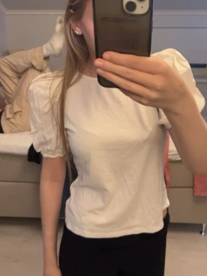 Vit topp med puffärmar - Säljer en vit topp med puffiga kortärmar från h&m.har aldrig använt den så den är som ny utan prislapp.