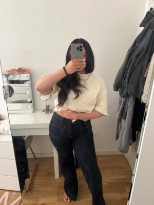 Mörkblå utsvängda jeans med fickor - Säljer ett par mörkblå jeans med raka, utsvängda ben. De är i hög midja och lite stretchiga. Endast använd ett fåtal gånger. Jag är 164 och tycker att de är lite för långa på mig. 