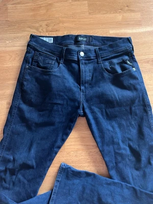 Mörkblå jeans från Replay - Snygga mörkblå jeans från Replay, modell Anbass slim. Storlek 32. Tillverkade i stretchigt denimtyg för extra komfort. Perfekta för en trendig och avslappnad stil.