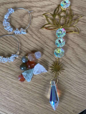 Spirituellt set - Spirituellt set. Säljer ett par stora, runda örhängen i silverfärgad metall med vita, oregelbundna pärlor i stengods-look. Örhängena har en bohemisk och trendig känsla, perfekta för dig som gillar statement-accessoarer och naturliga material. Åtta vackra stenar samt en stor solfångare som glittrar vackert i solen. 