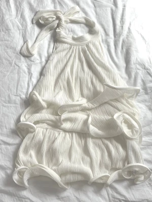 NAKD volang halterneck topp - Vit halterneck volang topp från NAKD. Knut i nacke. Så vacker!🤍 Pris: 120kr❤️storlek xs.