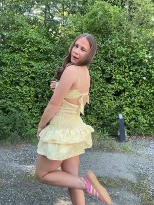 Gul- och vitrandig volangklänning - Supersöt kort klänning i gul- och vitrandigt med volanger och smockad midja. Axelbandslös look med smala axelband, öppen rygg och rosett i ryggen. Perfekt för soliga dagar och sommarhäng. En liten defekt i armhålorna men inget som syns. 