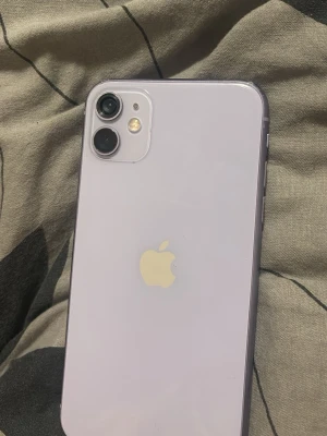 Lila iPhone 11 med glasbaksida - Jag säljer telefonen eftersom jag inte är nöjd med den, säljaren vill inte ha tillbaka den så jag säljer och köper en annan istället.  Batteriet är bytt. Den bakre kameran har en mindre skada, vilket den redan hade när jag köpte telefonen. I övrigt fungerar telefonen som den ska.  Jag fick varken originalkartong eller laddare vid köpet, så det medföljer inte heller vid försäljningen.  Priset kan diskuteras vid seriöst intresse. Jag vill gärna sälja telefonen så snart som möjligt ⭐️⭐️