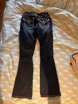 Mörkblå Miss Me bootcut jeans - Säljer mina fina Miss Me jeans då dom ej kommer till användning. Dom har tidigare varit uppsydda men har lagt ner dom igen så det är ett veck men det går nog att stryka bort. I övrigt så är dom som i nyskick, knappt använda. Köpta på Joord för 2199kr för ca 2 år sedan. 