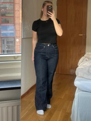 Mörkblå raka jeans från Gina tricot - Säljer ett par mörkblå raka jeans från Gina tricot. Jeansen har raka ben och är gjorda väldigt bekvämt jeansmaterial med lite stretch i, de har snygga sömmar framtill. 