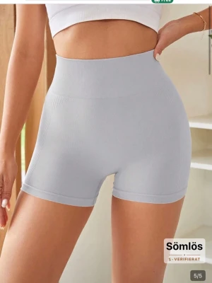 Ljusgrå tränings shorts - Snygga ljusgrå shaping-shorts med hög midja och sömlös design som formar och slätar ut siluetten. Tillverkade i ett stretchigt och mjukt material som sitter bekvämt mot kroppen. Perfekta under klänningar eller kjolar för en smickrande look. Skriv om ni har några funderingar ❤️