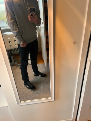 Svarta Replay Anbass  - Svarta Replay Anbass jeans i slim fit med klassisk femficksdesign och diskret Replay-logga vid fickan. Jeansen har smal passform, låg midja och är tillverkade i stretchigt bomullsmaterial för en bekväm känsla. Perfekta för dig som gillar en slimmad look.