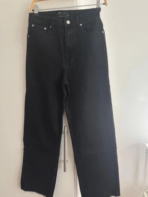 Svarta raka jeans W28 L32 - HELT NYA! Svarta jeans  med rak passform och hög midja. Jeansen har råa, avklippta benslut och klassiska fem fickor. 