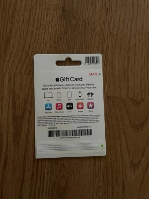 Apple presentkort 100 kr - Apple presentkort på 100 kr som kan användas till alla Apple-relaterade produkter, appar, spel, musik, filmer, tv-serier, iCloud och tillbehör. Kortet är vitt med färgglad Apple-logga och tydlig text på både fram- och baksida.