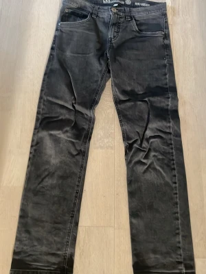 Svarta raka jeans - Säljer ett par svarta jeans  med raka ben och klassisk femficksmodell. Jeansen har en lätt tvättad look och silverfärgad knapp. Perfekta för dig som gillar en avslappnad stil.