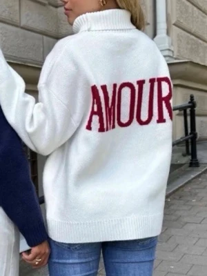 Vit stickad tröja med röd text - Säljer en vit stickad tröja med hög krage och stor röd text 'AMOUR' på ryggen. Sen är från meet me there🩷