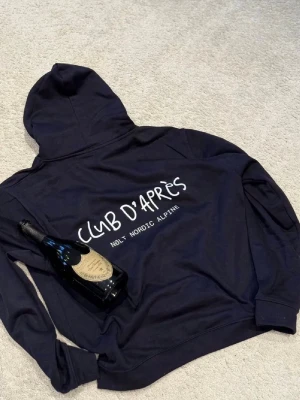 CLUB D'APRÈS Hoodie - Säljer en schysst blå hoodie med tryck både fram och bak. Skick: 10/10. Storlek M passar S / M. Nypris: 949. 