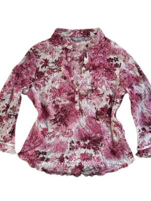 Blommig blus från Per Una - Off-white blommig trekvartsärmad blus med rosa blommigt mönster, v-ringning, knappdetaljer och volangändar 💗Skulle säga att blusen är liten i storlek! Jag brukar ha strl XS i toppar för referens 