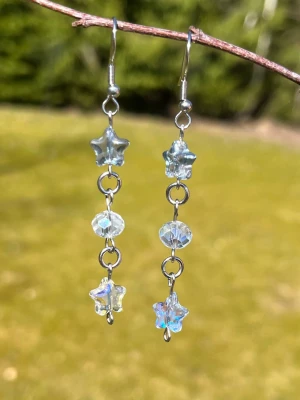 Örhängen  - Vackra örhängen av facetterade och stjärnformade glaspärlor. Metallen är rostfritt stål🌌✨