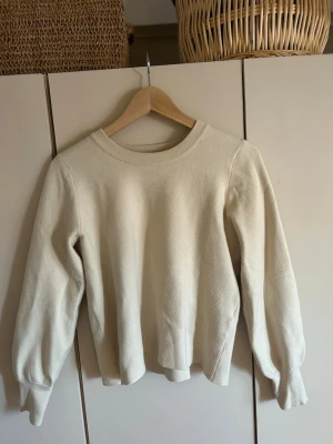 Mysig beige stickad tröja!! - En stilren krämvit stickad tröja med rund halsringning och långa ärmar. Tröjan har ribbade muddar vid halsen och ärmsluten, och är tillverkad i ett mjukt, bekvämt material. Perfekt för lager på lager under kyliga dagar. Passar till årencip allt!!💓💓 (knappt använd) ( pris går att diskutera) 
