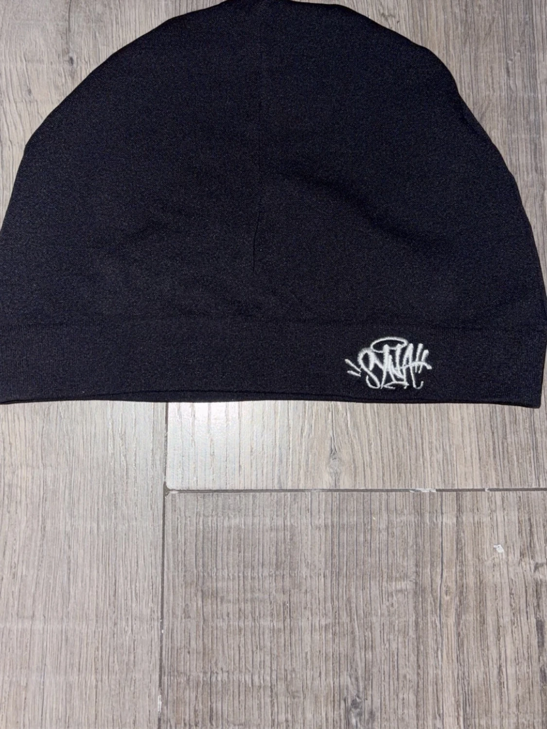 Svart syna world skull cap med vit logo