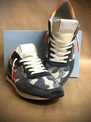 Philippe Model TRPX Camo  - Philippe Model TRPX Camo – nästan nya – storlek 42  Säljer ett par riktigt snygga Philippe Model TRPX Camo i storlek 42.  Skorna har camo-mönster med svarta och orange detaljer som gör att de sticker ut utan att bli för mycket. Passar till det mesta.  ✔ Storlek: 42 ✔ Skick: Nästan nya (väldigt lite använda) ✔ Nypris: 4000 kr ✔ Pris: 1249 kr  Säljer dem då de inte kommer till användning.  📩 Hör av dig vid intresse! 