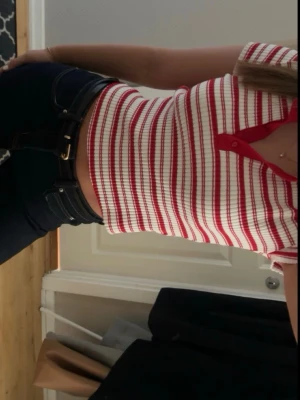 Randig ribbad pikétopp i rött och vitt - Hej! Säljer en trendig ribbad pikétopp med röda och vita ränder. Toppen har korta ärmar, knappar framtill. Säljer pga att inte kommer till användning, använd endast en gång💞