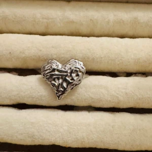 Paket 4 ringer  - Två unika ringar i silverfärg, en med ett coolt, skulpterat hjärta och en öppen ring med två hjärtan täckta av gnistrande stenar. Perfekt för dig som gillar trendiga och romantiska accessoarer med det lilla extra.