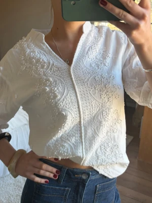 Vit broderad blus med v-ringning - Söt vit blus med broderier framtill 