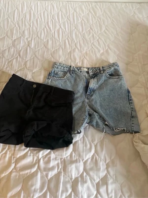 Två par jeansshorts, svart & blå Levi's - Säljer två par jeansshorts, ett par svarta och ett par ljusblå från Gina Tricot. Båda har klassisk femficksdesign och råa kanter nertill för en avslappnad look. Perfekta till sommaren och lätta att matcha med olika outfits. Dom svarta är i st M och då blåa i S