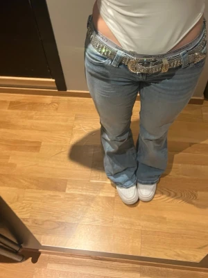 Ljusblå Lågmidjade bootcut jeans - ljusblå bootcut jeans med snygg brodyr på bakfickorna. Jeansen har väldigt låg midja. Använda fåtal gånger, sitter som S, storlek är 14+ från gina. Bra i Längd på mig (160cm)