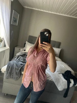 Rosa kortärmad skjorta med knappar - Säljer en rosa skjorta med korta ärmar och knappar framtill. Just nu är den inte strykt så därav är den skrynklig men går ju enkelt att stryka om man vill 💞