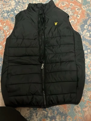 Svart dunväst från Lyle & Scott - Snygg svart dunväst från Lyle & Scott i storlek 14 till 15 år typ aldrig använt. Öppen för prisförslag💕