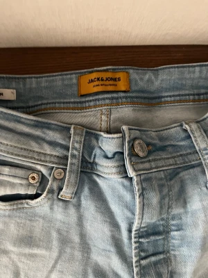Ljusblå slim fit jeans Jack & Jones - Snygga ljusblå slim fit jeans från Jack & Jones med klassisk femficksdesign och bälteshällor. Jeansen har en fräsch tvätt och raka ben, perfekta för en avslappnad stil. Materialet är mjuk denim som sitter skönt hela dagen.