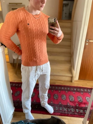 Persikofärgad kabelstickad tröja Morris - Men gudars skymning vilken skönhet till tröja nu till vår/sommar!☀️En persikofärgad stickad tröja från Morris som sitter som ett smäck för dig som har storlek M eller S.🫵🙌En personlig favorit för mig nu till de svala sommarkvällarna som väntar! Tveka inte att höra av er kring funderingar!🫶