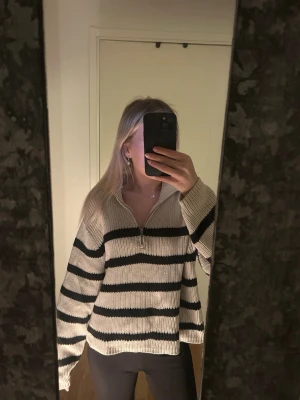 Randig halv zip stickad  - Beige stickad tröja med svarta ränder från Lindex tröjan har även en halv zip och är ett tjockt stickat material😊