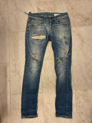 Dondup jeans  - Blå dondups i strlk 30. Jeansen är i okej skick då den har lite små slitage och hål men inget som syns vid användning. Dem har även stora slitningar fram till. Där av billigt pris! Hör av er vid frågor!