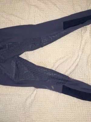 Ridbyxor & schabrak - Två par ridbyxor & schabrak (se sista bild).  Ett par Marinblåa JH collection ridbyxor samt ett par svarta CRW. Strl 34 i båda De blåa är lite slitna nedtill (se bild) annars fina & hela.  Schabrak i strl Ponny/shetland, även täcken finns.  Skriv för pris