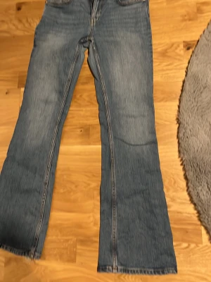 Blå bootcut jeans i storlek S - Bootcut jeans från 157 i klassisk blå denim med ljusa slitningar och kontrastsömmar. Modellen har normal midja och är i längd short. Perfekt för dig som gillar en avslappnad och trendig look.