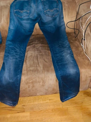 Replay x f.c Barcelona jeans - Snygga blå bootcut jeans med ljusa slitningar framtill och klassiska bakfickor med sömmar. Jeansen har normal midja och är tillverkade i denim med lite stretch för skön passform. Perfekta för en avslappnad och trendig look.