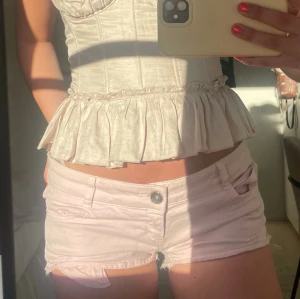 Ljusrosa denimshorts med knapp🩵 - Säljer ett par ljusrosa shorts i denim med låg midja och knappstängning framtill. De har klassiska fickor och en kort, tight passform som är perfekt för varma dagar. Snygga att matcha med en topp eller hoodie.