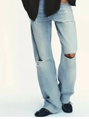 Lågmidjade baggy jeans  - Säljer ett par trendiga lågmidjade ljusblåa lite baggy jeans från Zara med hål💞Dom är lite slitna nedtill så skriv för fler bilder! 