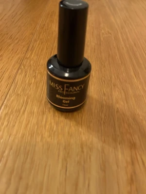 Miss Fancy Blooming Gel nagellack - Miss Fancy Blooming Gel är ett gel-nagellack i svart flaska med guldig text. Perfekt för att skapa coola effekter på naglarna. Innehåller 15 ml och passar dig som gillar att experimentera med nageldesign.