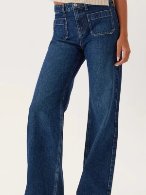 Mörkblå wide leg jeans med fickor - Säljer ett par mörkblå jeans med breda ben och stora fyrkantiga framfickor. Jeansen har hög midja och klassisk denimlook. Perfekta för dig som gillar en avslappnad och trendig stil. Materialet är kraftig bomullsdenim.