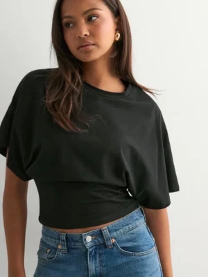 Svart croppad topp med indragen midja - Svart topp från Nelly med indragen midja..