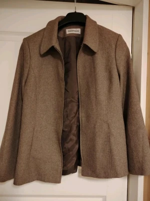 Vintage Brun kavaj från Tuomiss❤️  - Stilren brun kavaj från Tuomiss med klassisk krage och figursydd passform❤️ Kavajen har helfodrad insida och är tillverkad i ett mjukt tyg som ger en dressad look😍 Perfekt för dig som gillar en tidlös och enkel stil🤍 