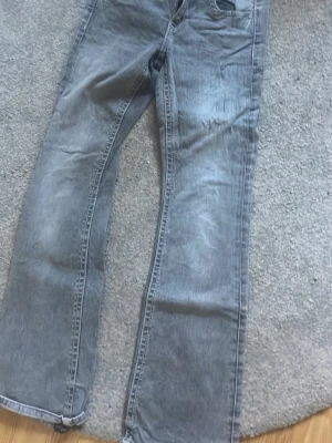 Ett par jättefina gråa jeans - Detta är ett par jättefina gråa jeans från Gina dem har ett hår längst ner vid jeansen man kan ha dessa till en jätte fin somrig tröja