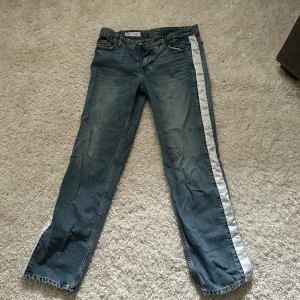 Blå jeans med vit sidoremsa - Blå jeans med vita strips på sidan. Lite baggy och as snygga och coola. Bra skick! Pris kan diskuteras 
